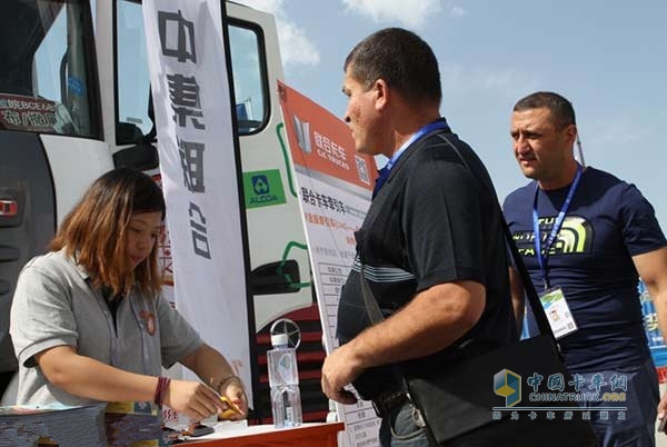 在亞歐博覽會室外嘉年華展區(qū)，聯(lián)合卡車營銷服務(wù)人員正在接待兩名俄羅斯客戶
