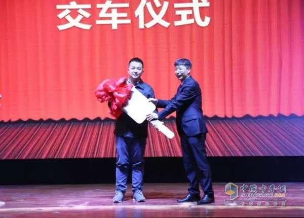 一汽解放銷售有限公司黨委副書記孫明志將第兩萬(wàn)臺(tái)訂單車鑰匙交付給車主