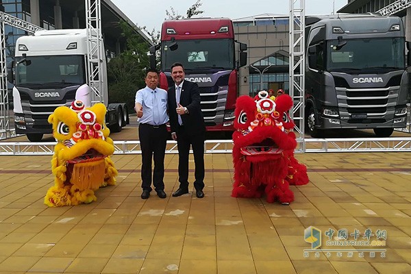 　濟(jì)寧市瑞力汽車有限公司董事長賈永存和斯堪尼亞中國財(cái)務(wù)總監(jiān)史蘭德為新品以及舞獅表演點(diǎn)贊
