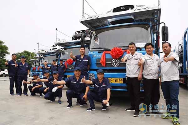 工作人員與東風(fēng)天錦中置軸轎運改裝車合影留念