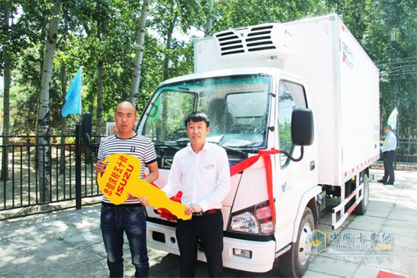 北京忠信慶鈴汽車貿(mào)易有限公司總監(jiān)梁緣向購(gòu)車用戶交接鑰匙