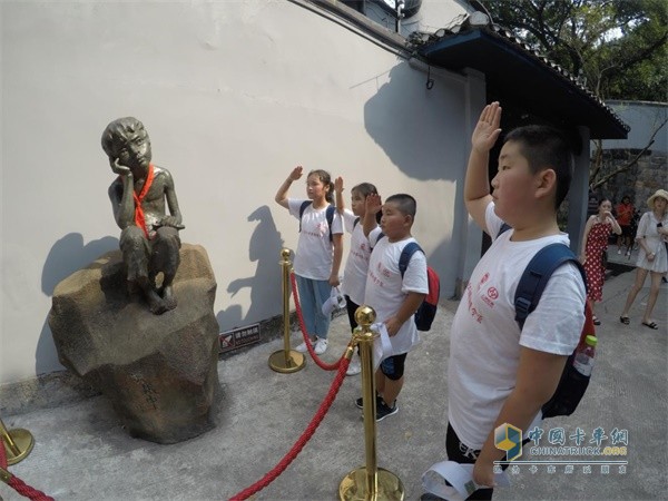 同學(xué)們向小蘿卜頭的雕像敬禮，感受革命時期“紅巖精神”的力量