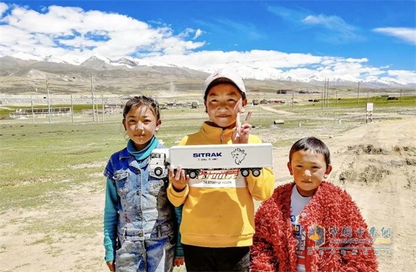 孩子們和中國重汽汕德卡合影