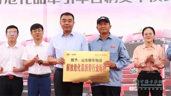 一汽解放汽車銷售有限公司副總經(jīng)理張松為山東順華物流有限公司董事長(zhǎng)單提民遞送獎(jiǎng)牌
