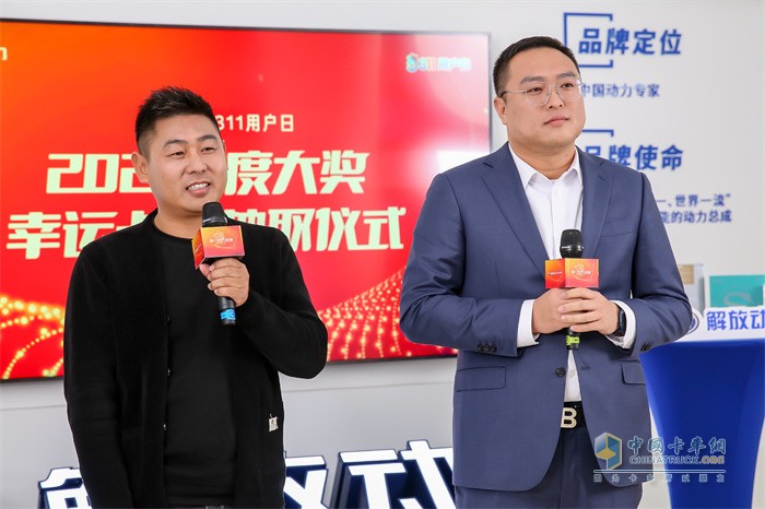 魚快創(chuàng)領(lǐng)副總經(jīng)理張中磊(右)與2020年解放節(jié)油大賽冠軍吳前方(左)抽取第四輪發(fā)動機大獎