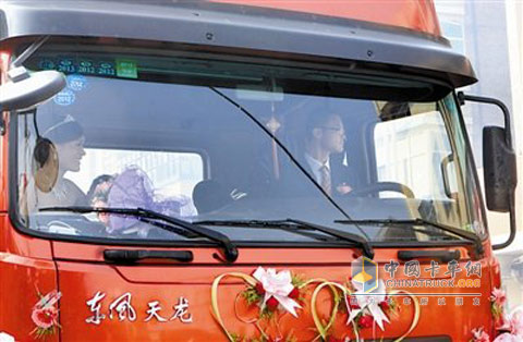 新郎新娘坐在東風(fēng)天龍的婚車上